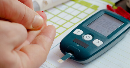 A man pricks his finger to measure his blood sugar level as part of diabetes management. This monitoring helps him keep track of his health effectively.