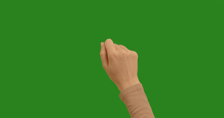 Young woman knocks on the green screen background with her hand. Gestures pack on chroma key green screen background, like using a touchscreen.