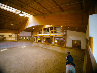 Equestrian wearing helmet riding horse training it for competition. Young girl having riding lesson being savety equiped.