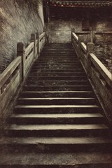 Worn stone steps of ancient Chinese architecture with aged wooden railings and textured stone walls, vintage aesthetic with dark tones and grainy texture.