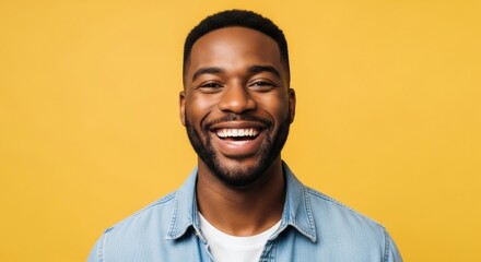 Fototapeta premium Genuine smile from a young African American man radiates happiness on yellow backdrop