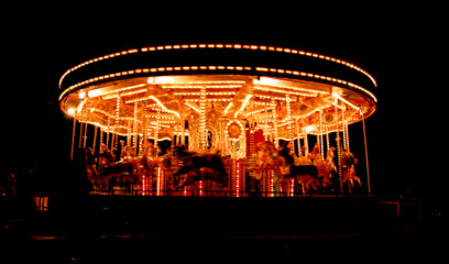 A brightly lit carousel at night.