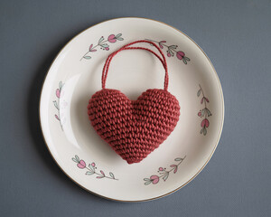 Charming crocheted heart ornament presented on a decorative plate, evoking feelings of handmade love and cozy domesticity.