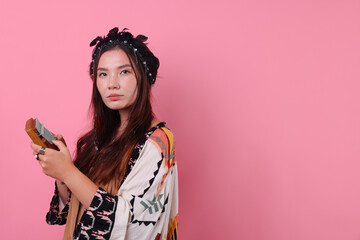 Shaman woman in feather headdress with kalimba on pink background, space for text
