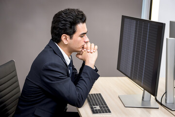 Serious young businesswoman looking at desktop screen, analyzing data information at working desk in office. Thinkful data analyst works with desktop computer, feels stressed. Tired business worker