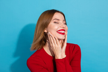 Beautiful woman with radiant smile in red attire against a blue background exuding confidence and...