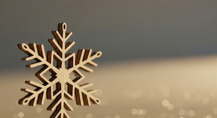 A wooden snowflake ornament with layered construction set against a blurred beige and gray background