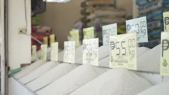 Various types of premium local rice displayed for sale in a public market with visible price tags in Philippine pesos, showcasing rice varieties, pricing, and food staples in the Philippines.