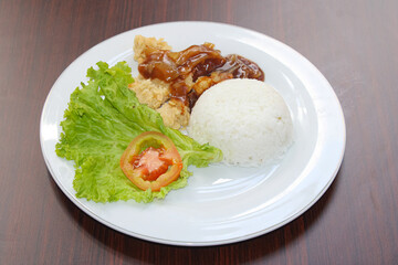 Crispy Fried Chicken with Rice and Fresh Vegetables on White Plate