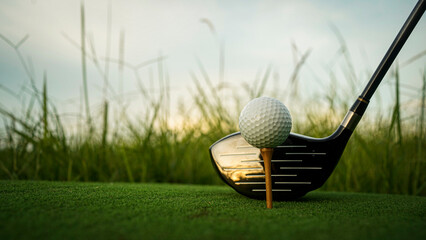 Golf ball on green grass in the evening golf course with sunshine background.