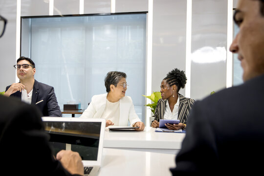 Group of diverse businesspeople at conference, happy business workers discussing and brainstorming together at meeting room. Cheerful officers exchange ideas and listen to presentations during meeting