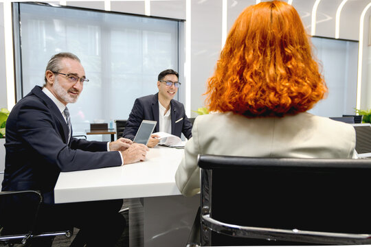 Group of diverse businesspeople at conference, happy business workers discussing and brainstorming together at meeting room. Cheerful officers exchange ideas and listen to presentations during meeting