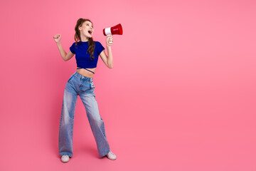 Fashionable woman with a megaphone expressing elation against a pink backdrop for promoting and lifestyle themes