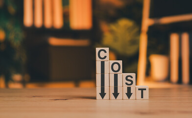 Concept of cost reduction and business savings. Wooden blocks spelling COST and downward arrows. Ideal for financial planning, expense management, and budget efficiency strategies. Business effective,