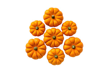 Group of small orange pumpkins arranged in a circular pattern on black background
