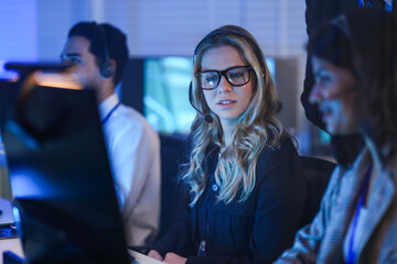 Focused female call center agent headset on provides expert support late night Modern...
