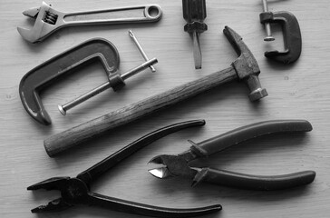 Arranged reliable hand work tools on a wooden table monochrome image