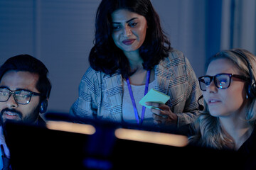 A future call center manager uses an AI platform showing predictive analytics on agent performance, identifying coaching needs in real time for optimized customer interactions.