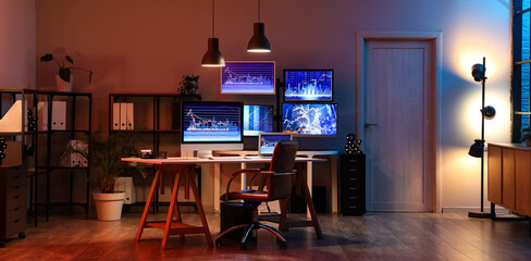 Interior of dark office with trader's workplace and glowing lamps at night