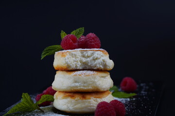 Sweet cottage cheese pancakes(sweet syrniki) on plate with raspberries