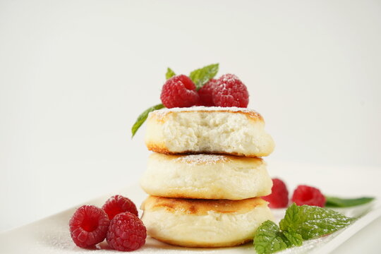 Sweet cottage cheese pancakes(sweet syrniki) on plate with raspberries