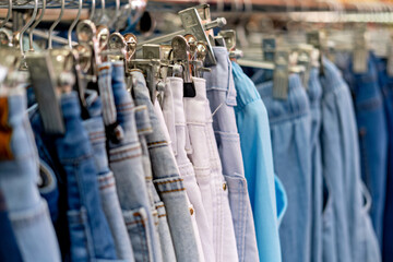 A rack of jeans in various colors and styles