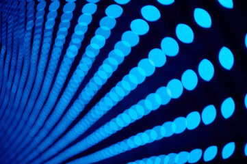 Garland lights with a blurred bokeh effect. Festive blue decorative lighting in a perspective concept. Background texture with LED lighting.	