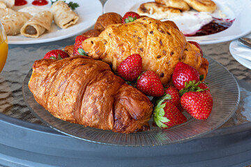A plate of food with strawberries and a pastry