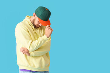 Handsome male hip-hop dancer on blue background