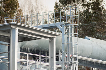 close-up of a pipeline against the backdrop of a green forest in winter