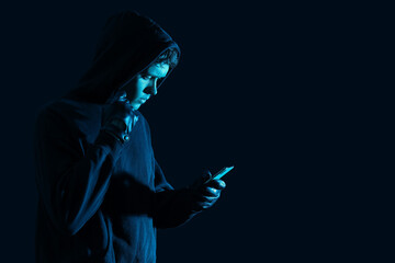 Male fraudster with mobile phone on dark background