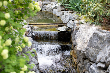 Waterfall near the stone falling in river in nature park