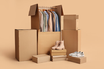 Wardrobe boxes with clothes and shoes on beige background