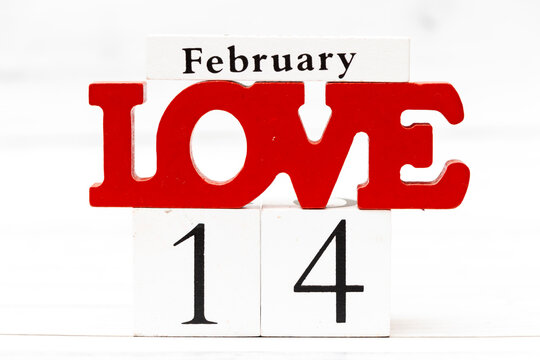 Decorative wooden blocks displaying the word Love and the date February 14, symbolizing Valentines Day and celebration of love and affection.