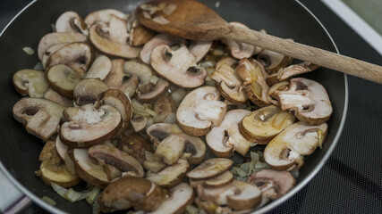 Fresh mushrooms and onions are sautéed together in a pan