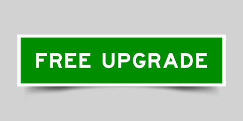 Green color square shape sticker label with word free upgrade on gray background