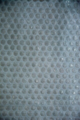 Fototapeta premium Close-up of plastic bubble wrap texture with soft light and shadow pattern