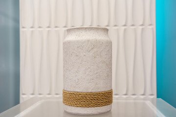 Unique white decorative vase with rope detail in a modern interior setting