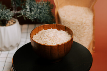 White rice served in a wooden bowl beside a bag of long grain rice