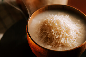 Long grain white rice served in a wooden bowl, steaming and ready to eat