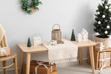 Interior of light room with table, lantern and Christmas tree