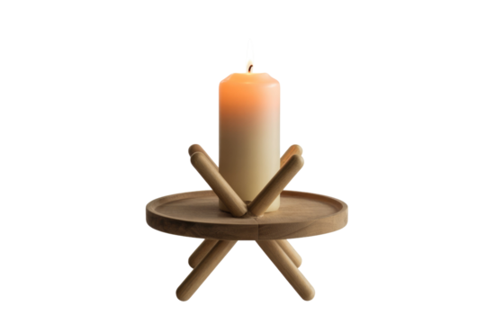A minimalist, lit pillar candle rests on a stylish wooden stand with a round tray and splayed legs. An elegant home decor item. background removed