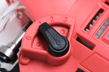 Close up of plastic adjustment switch on saw blade tilt jigsaw.