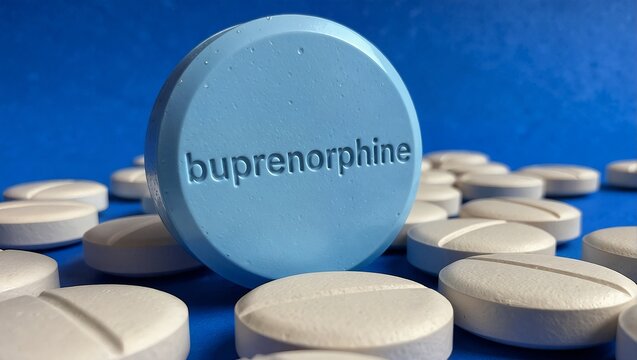 a blue pill imprinted with "buprenorphine" is surrounded by numerous white, oblong pills on a vibrant blue surface.