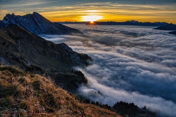 Sunrise hike above the sea of ​​fog to the Lütispitz in the Alpstein region of Toggenburg. A stunning sunrise above the fog with a view of Mount Säntis. Hiking in the Swiss Alps. High quality photo