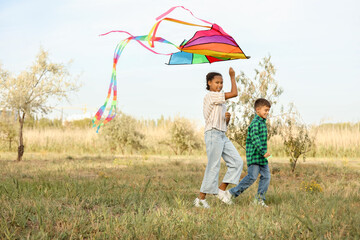 Cute children with kite running in park