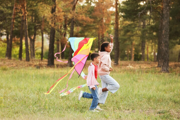 Happy children with kite running in nature