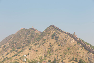 The Majestic Fortification Walls of Amer Fort Winding Across the Aravalli Hills Under a Pale Blue Sky, Jaipur, Rajasthan, India