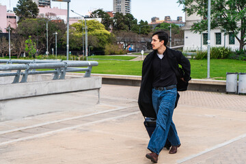 Man walking with luggage in urban park