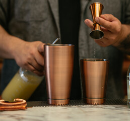 Bartender Measuring Liquor With Copper Jigger